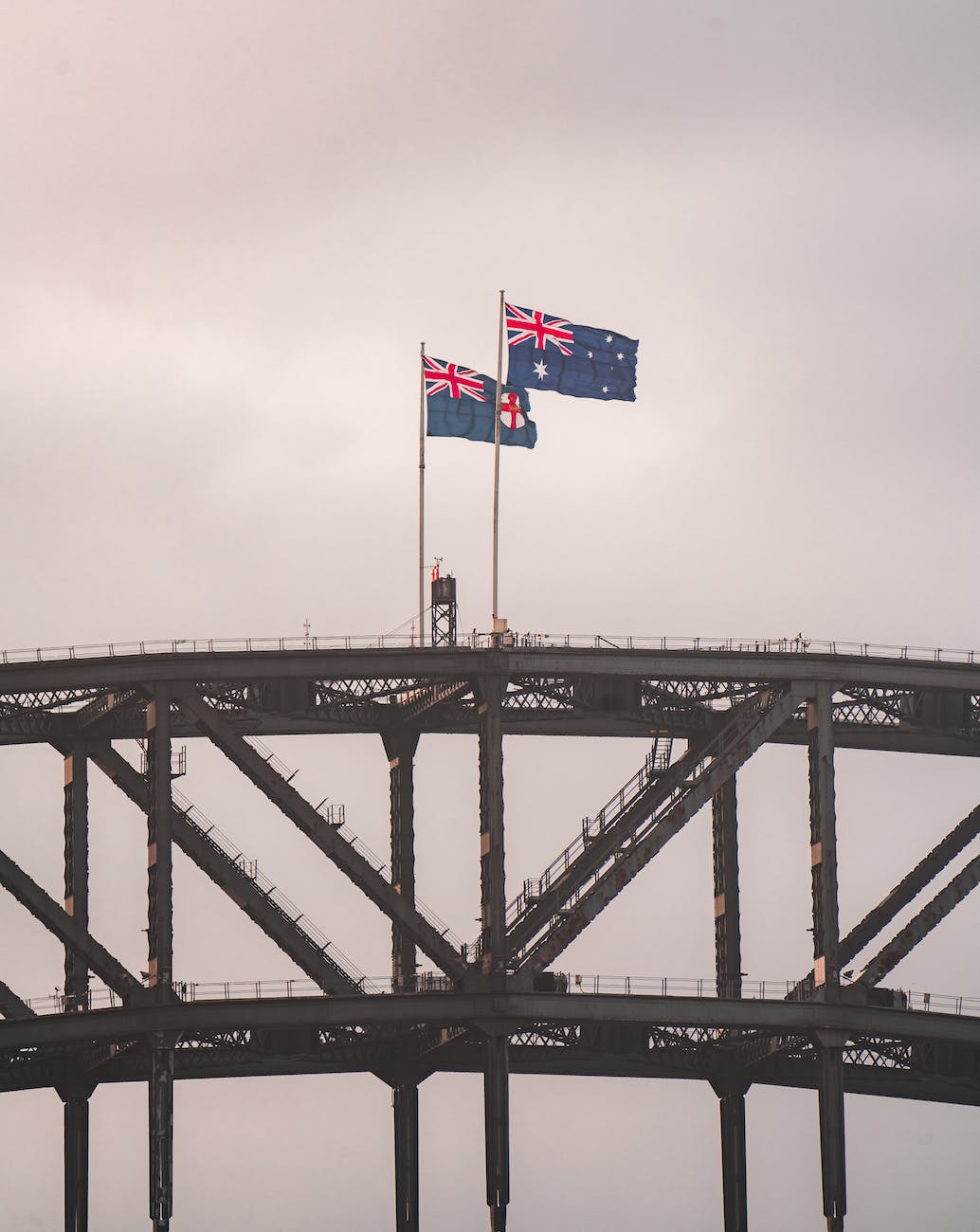 australian flags placed on sydney harbor bridge arch in twilight