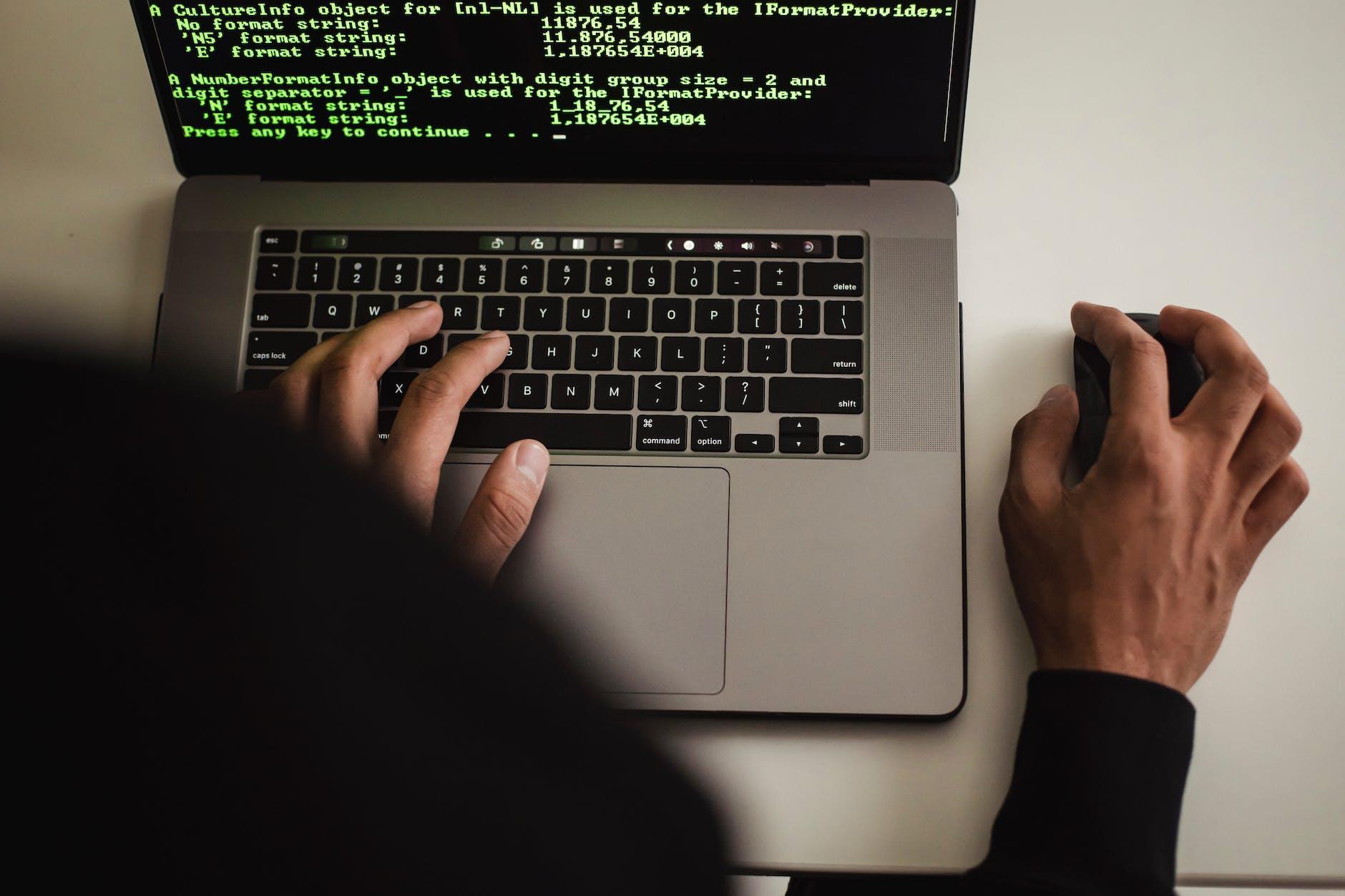 crop faceless programmer working on laptop in studio